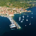 Komiža harbour on Vis island with boats and open Adriatic coastline